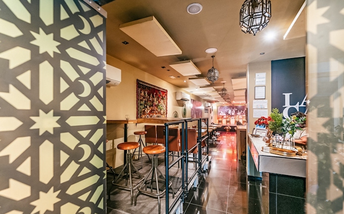 Flamenco show venue interior with bar seating and decorative wall panel.