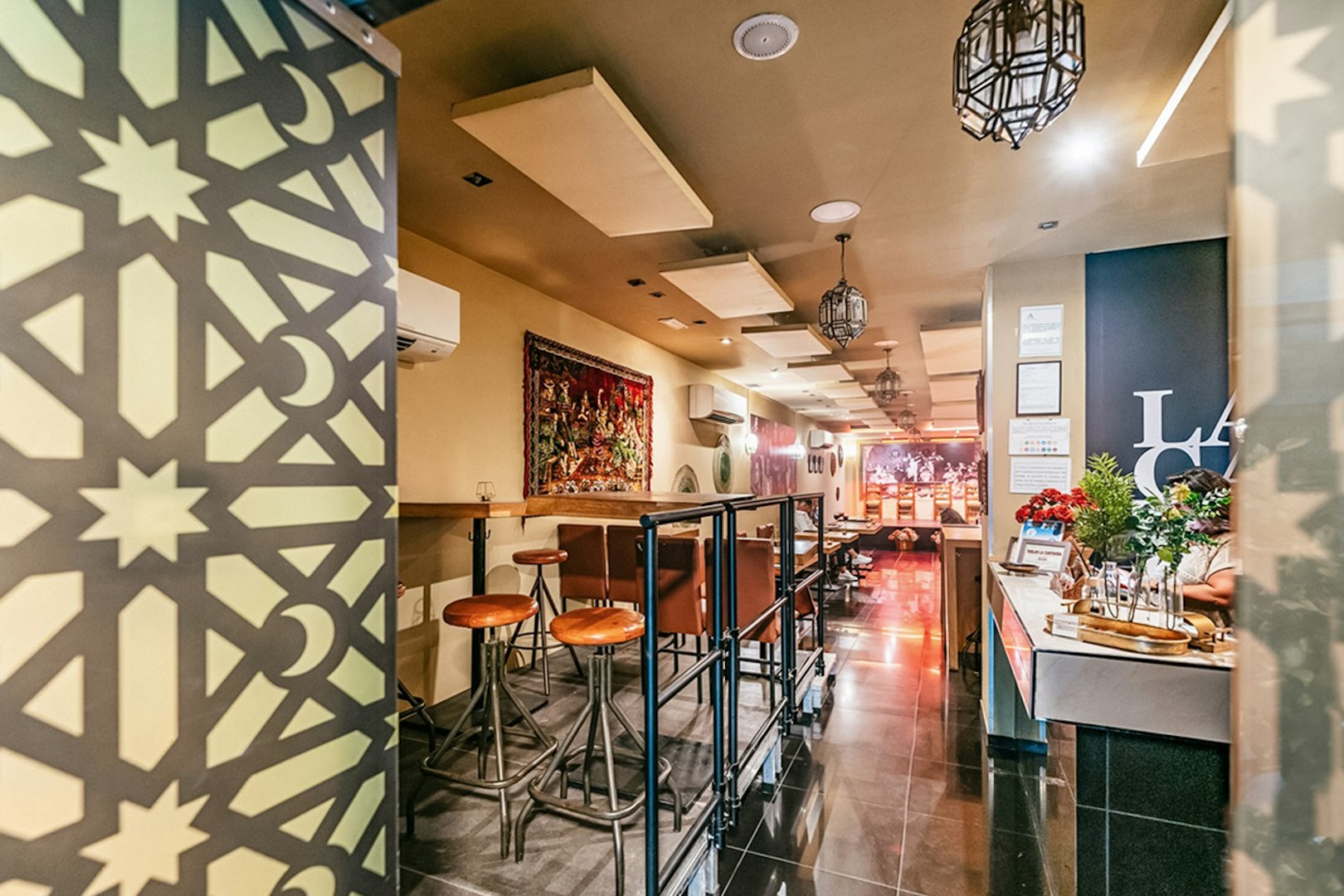 Flamenco show venue interior with bar seating and decorative wall panel.
