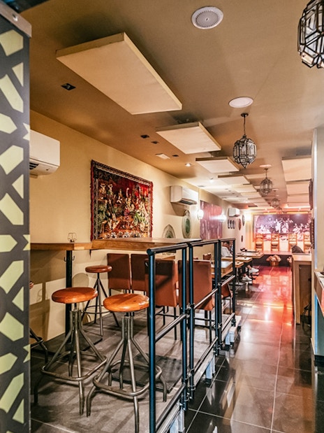 Flamenco show venue interior with bar seating and decorative wall panel.