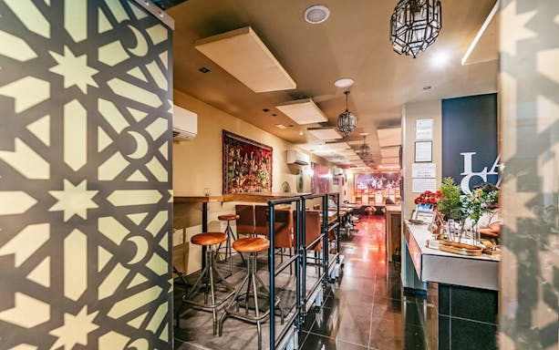 Flamenco show venue interior with bar seating and decorative wall panel.