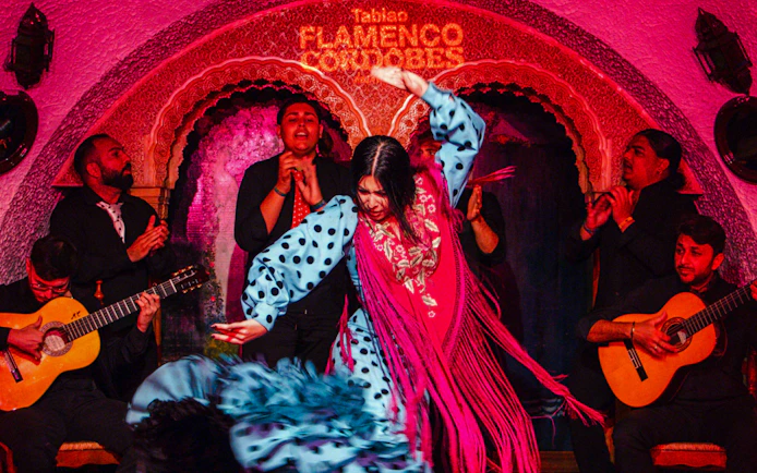 Flamenco dancers performing at Tablao Cordobes with musicians playing guitar.