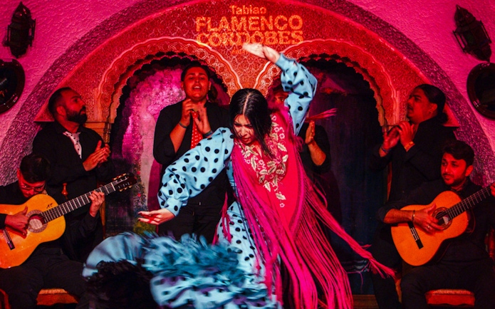 Flamenco dancers performing at Tablao Cordobes with musicians playing guitar.