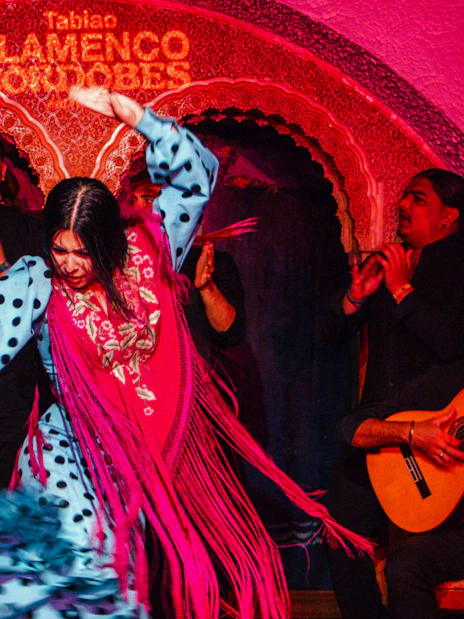 Flamenco dancers performing at Tablao Cordobes with musicians playing guitar.