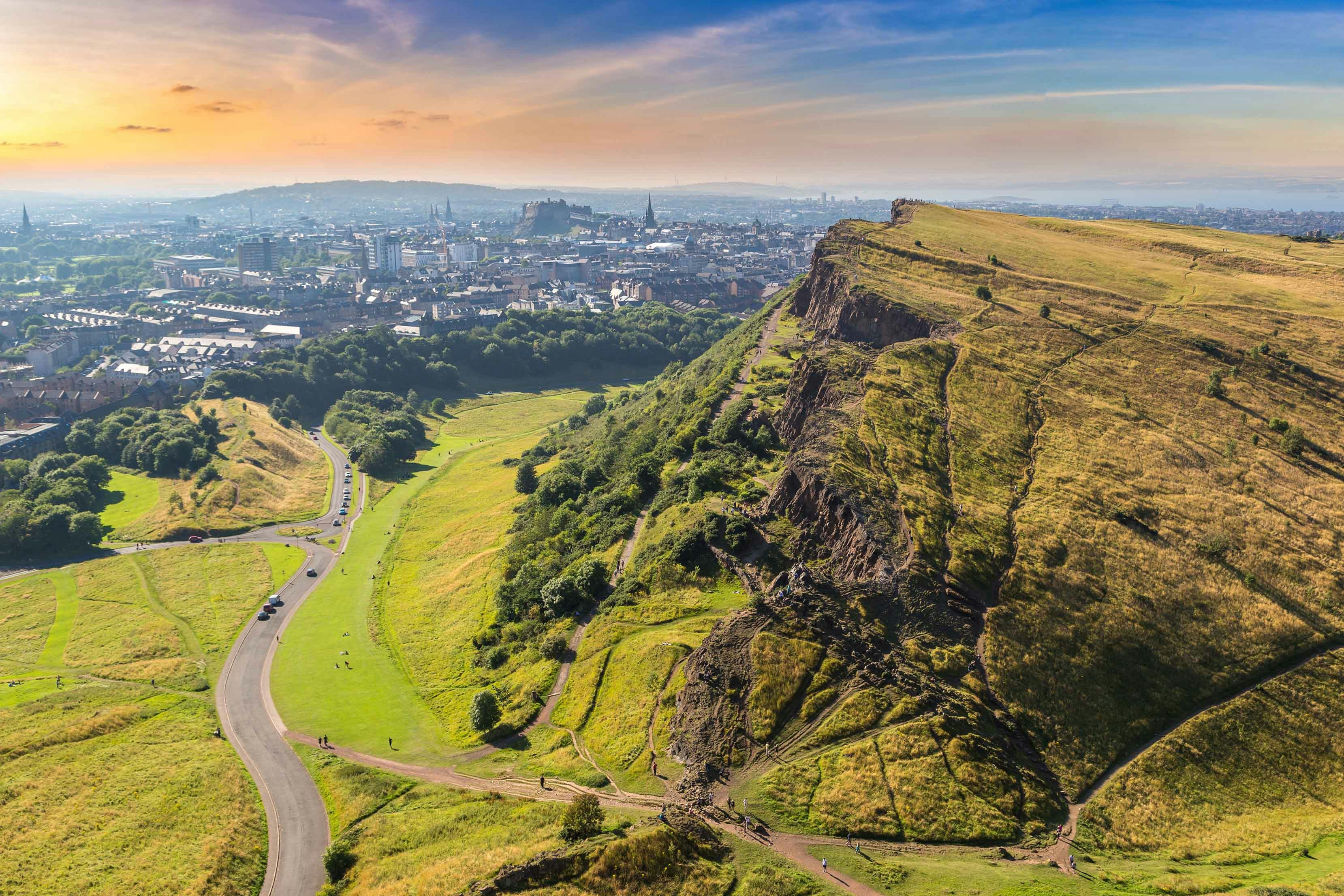 Arthur’s Seat overlooking Edinburgh cityscape at sunset.