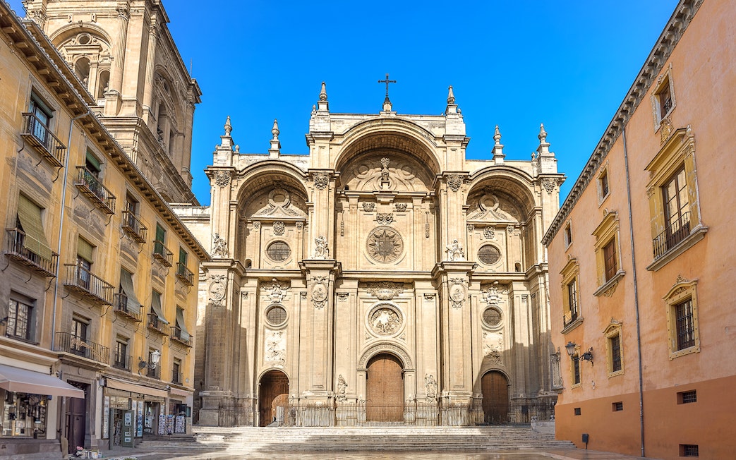 Granada Cathedral entrance with ornate facade and surrounding historic buildings.