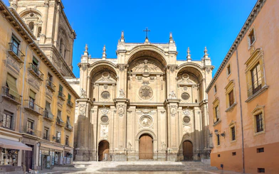 Granada Cathedral entrance with ornate facade and surrounding historic buildings.