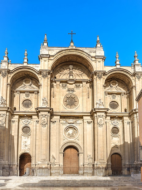Granada Cathedral entrance with ornate facade and surrounding historic buildings.
