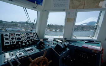 Boat cockpit view of Lake Yamanaka with Mount Fuji in the background.