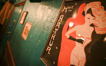 Madame Arthur cabaret show poster on a textured teal wall.