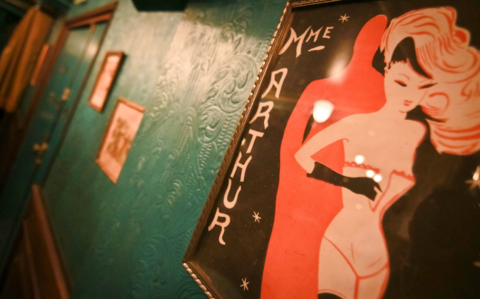 Madame Arthur cabaret show poster on a textured teal wall.