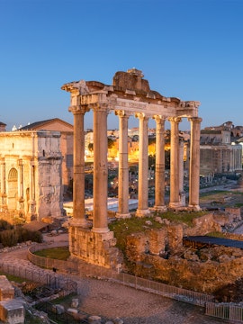 Roman Forum ruins with ancient columns at sunset in Rome, Italy.