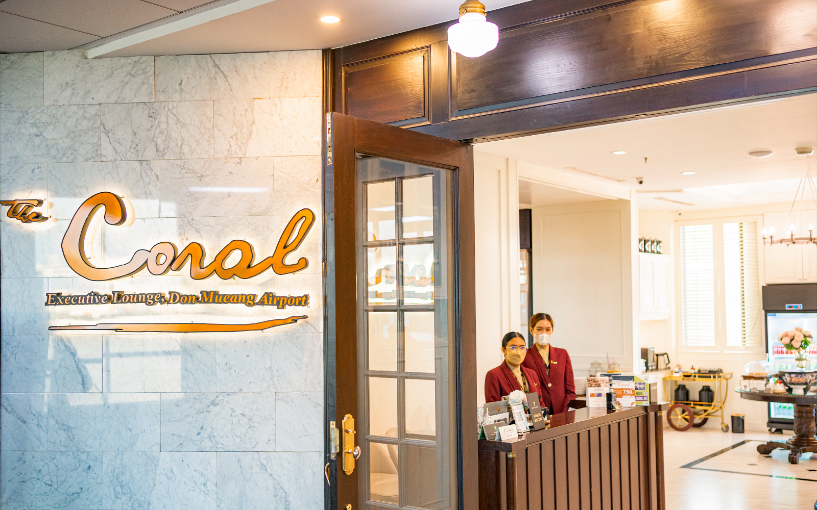 Entrance to The Coral Executive Lounge at Bangkok Airport, Thailand, with staff at reception.