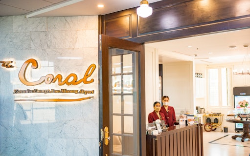 Entrance to The Coral Executive Lounge at Bangkok Airport, Thailand, with staff at reception.