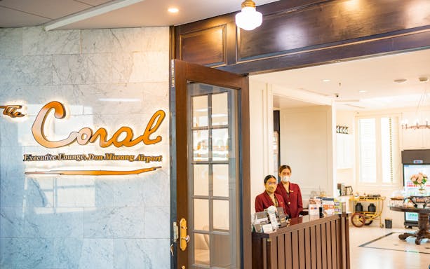 Entrance to The Coral Executive Lounge at Bangkok Airport, Thailand, with staff at reception.