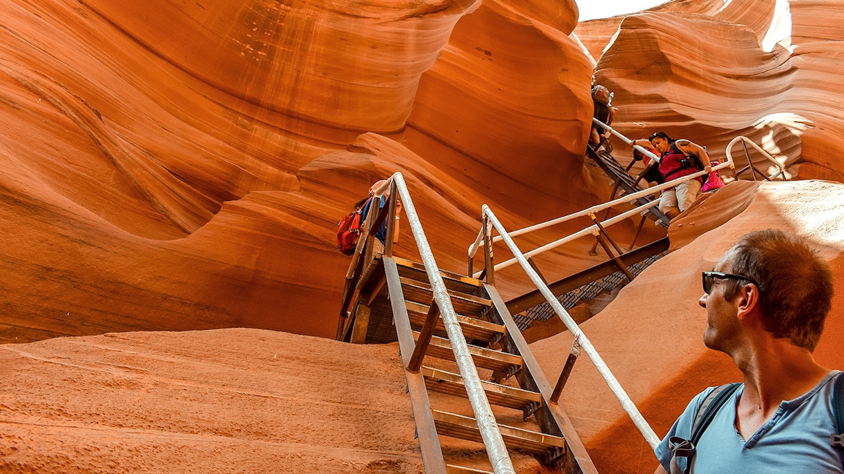 tourists climbing down staircase at antelope canyon