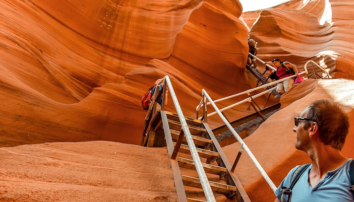Tourists climbing stairs in Lower Antelope Canyon, Arizona, during a day tour from Las Vegas.