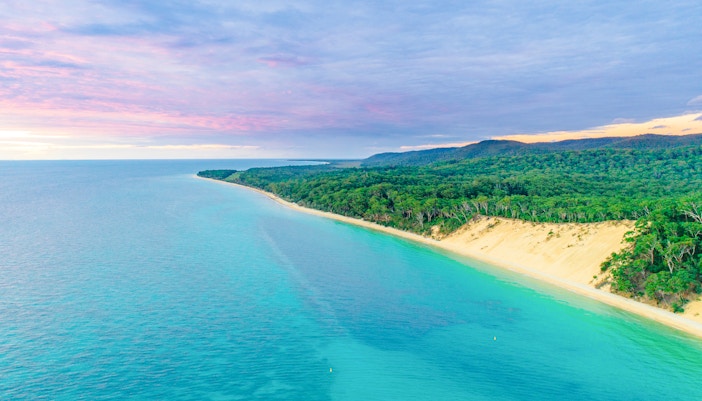 Aerial view of Moreton Island coastline with turquoise waters and lush greenery, Queensland, Australia.