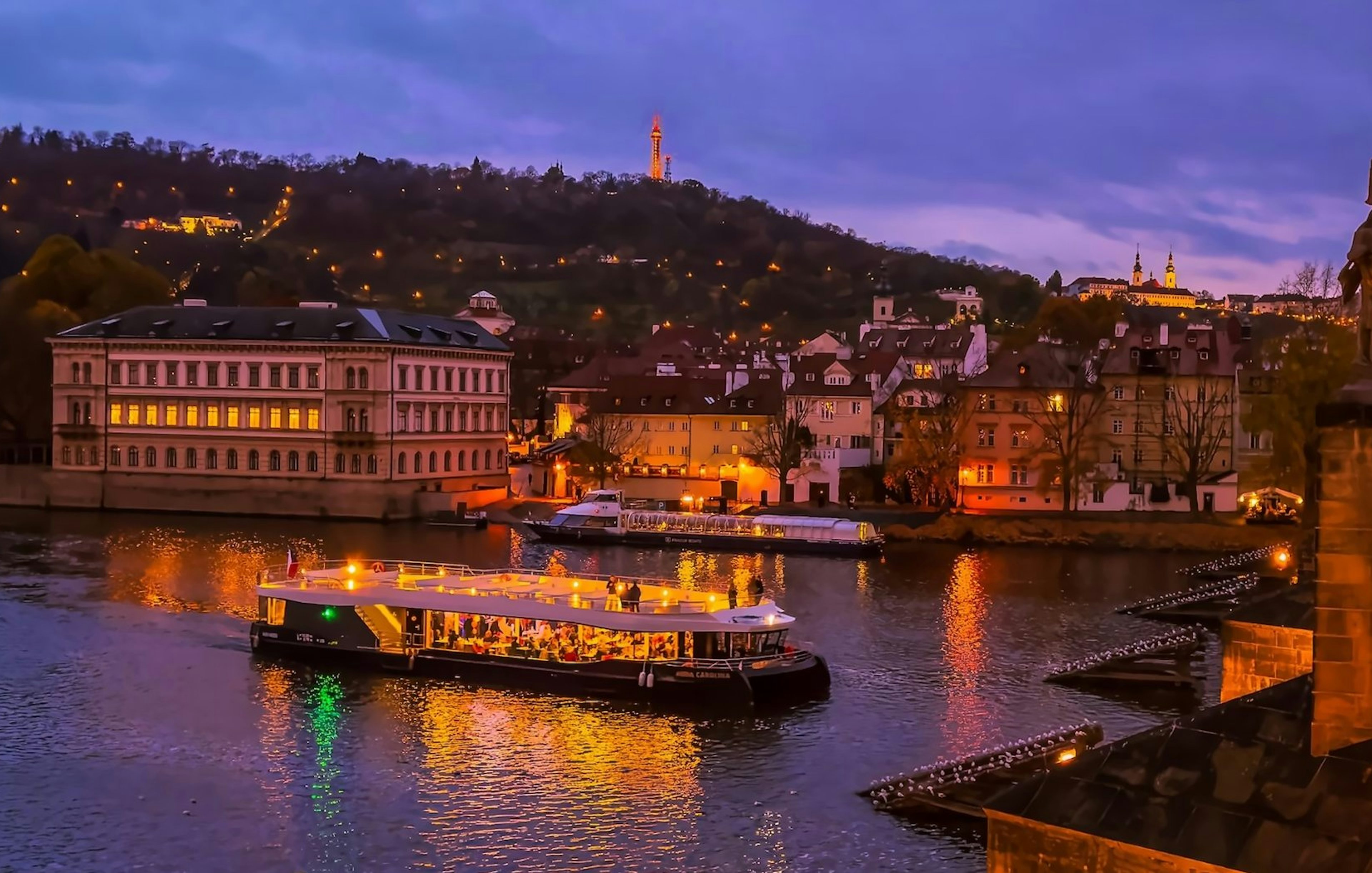 Evening cruise on Vltava River with Prague Castle in the background.