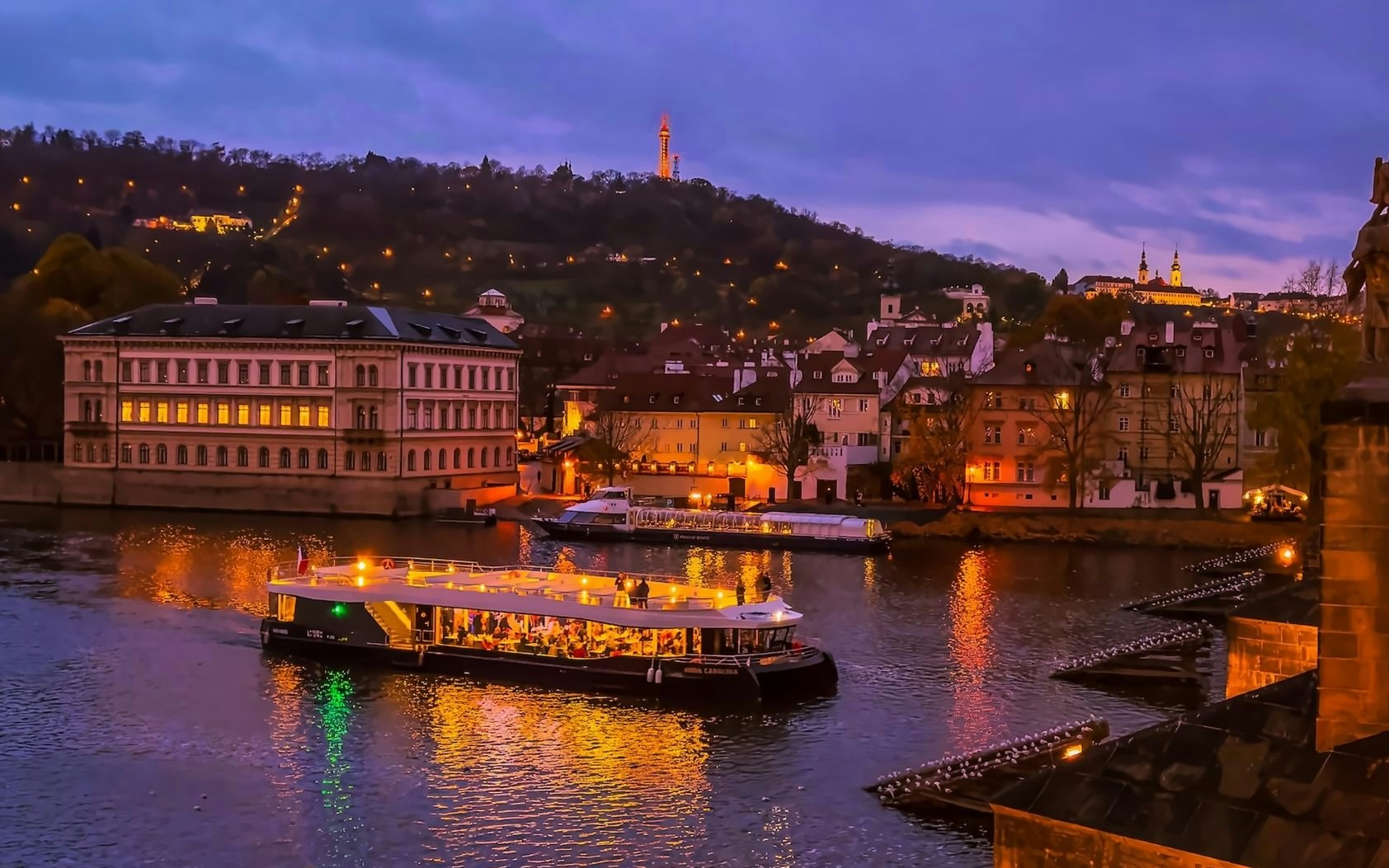 Evening cruise on Vltava River with Prague Castle in the background.