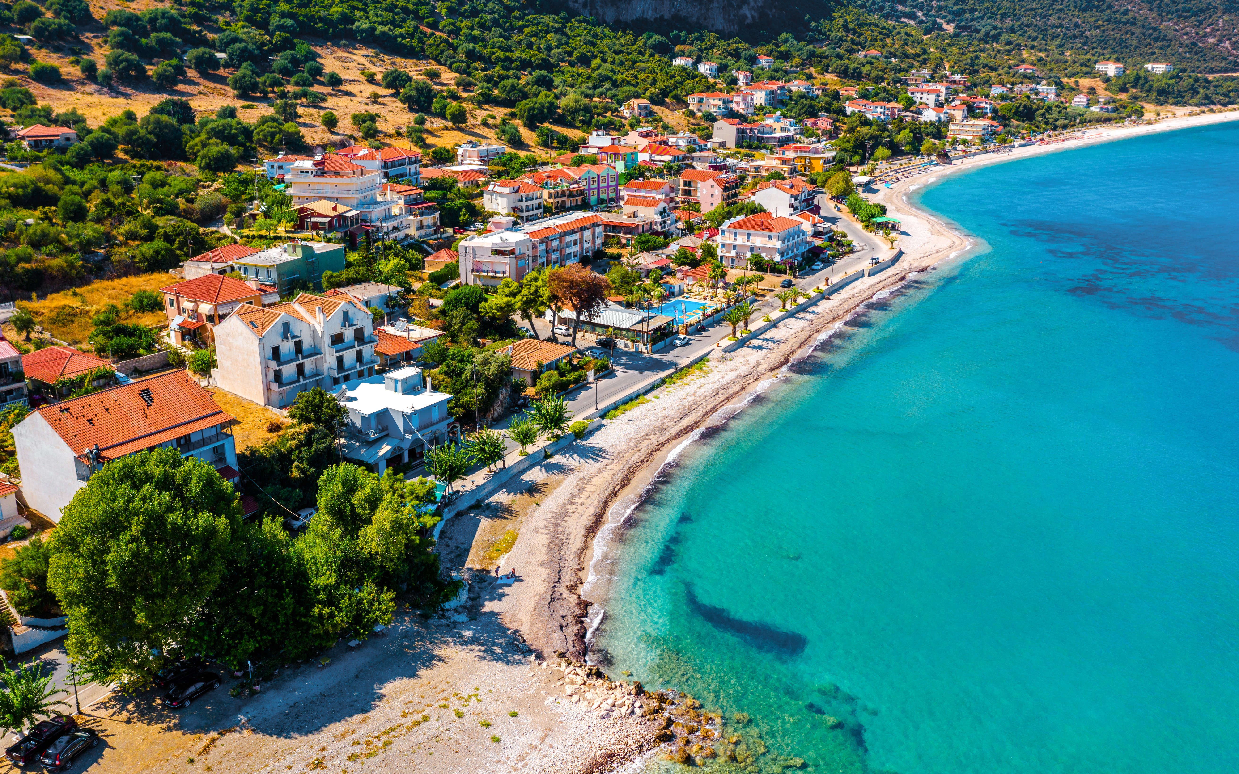 Aerial view of Poros coastline on Kefalonia island, Greece, with turquoise waters and coastal village.