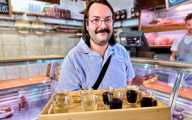 Local guide presenting wine samples during Rome Trastevere food tour.