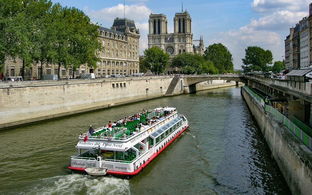 Seine River cruise boat near Notre-Dame Cathedral in Paris.