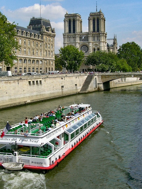 Seine River cruise boat near Notre-Dame Cathedral in Paris.