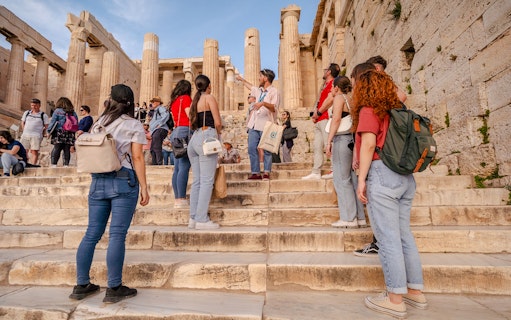 Tour group exploring the Parthenon with a guide in Athens, Greece.