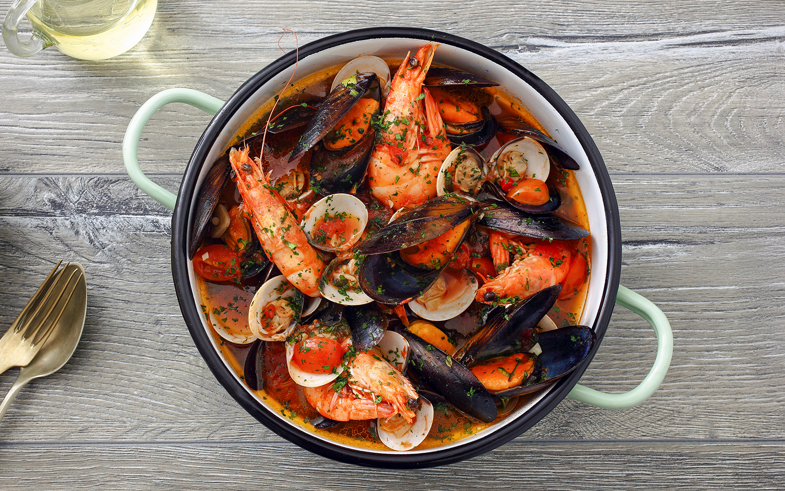 Zuppa di Cozze with tomato sauce on gray table background.