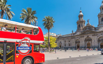 Turistik tour bus at Plaza de Armas, Santiago, Chile, with Metropolitan Cathedral in view.