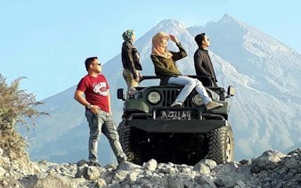 Group on Jeep during Merapi Lava Tour with mountain backdrop, Dubai.