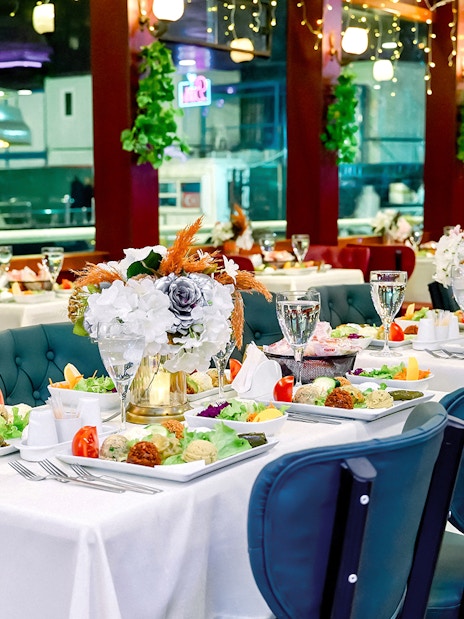 Table set for Turkish dinner on Bosphorus cruise with floral centerpieces and assorted dishes.