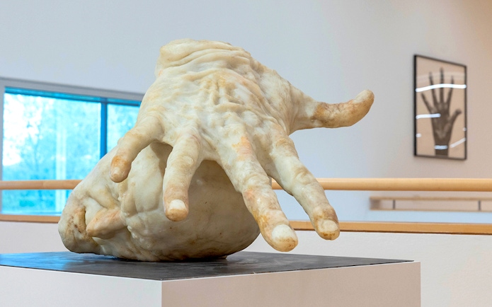 Sculpture of a large hand inside ALBERTINA KLOSTERNEUBURG exhibit.