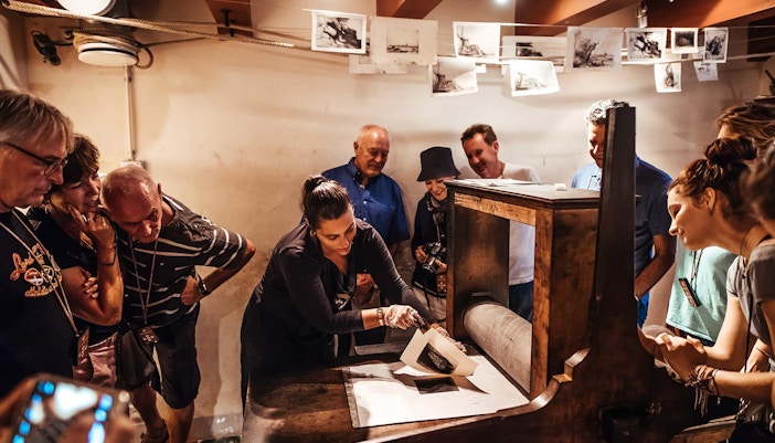 Guide demonstrating painting technique at Rembrandt House Museum, Amsterdam.