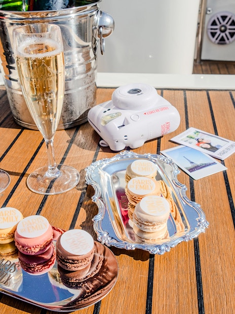Champagne glasses and macarons on a table during The Official Emily in Paris Champagne Seine Cruise.