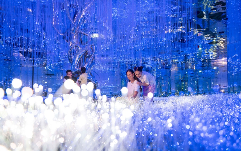 Visitors exploring the illuminated installations at AYA Universe.