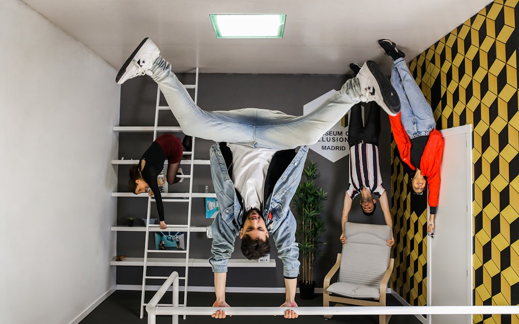 Visitors exploring an upside-down room at the Museum of Illusions in Madrid.