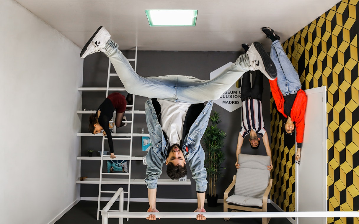 Visitors exploring an upside-down room at the Museum of Illusions in Madrid.