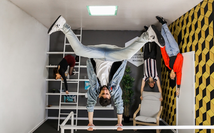 Visitors exploring an upside-down room at the Museum of Illusions in Madrid.