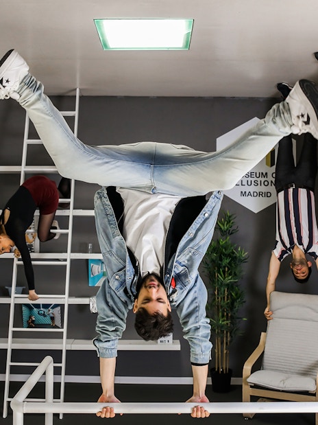 Visitors exploring an upside-down room at the Museum of Illusions in Madrid.