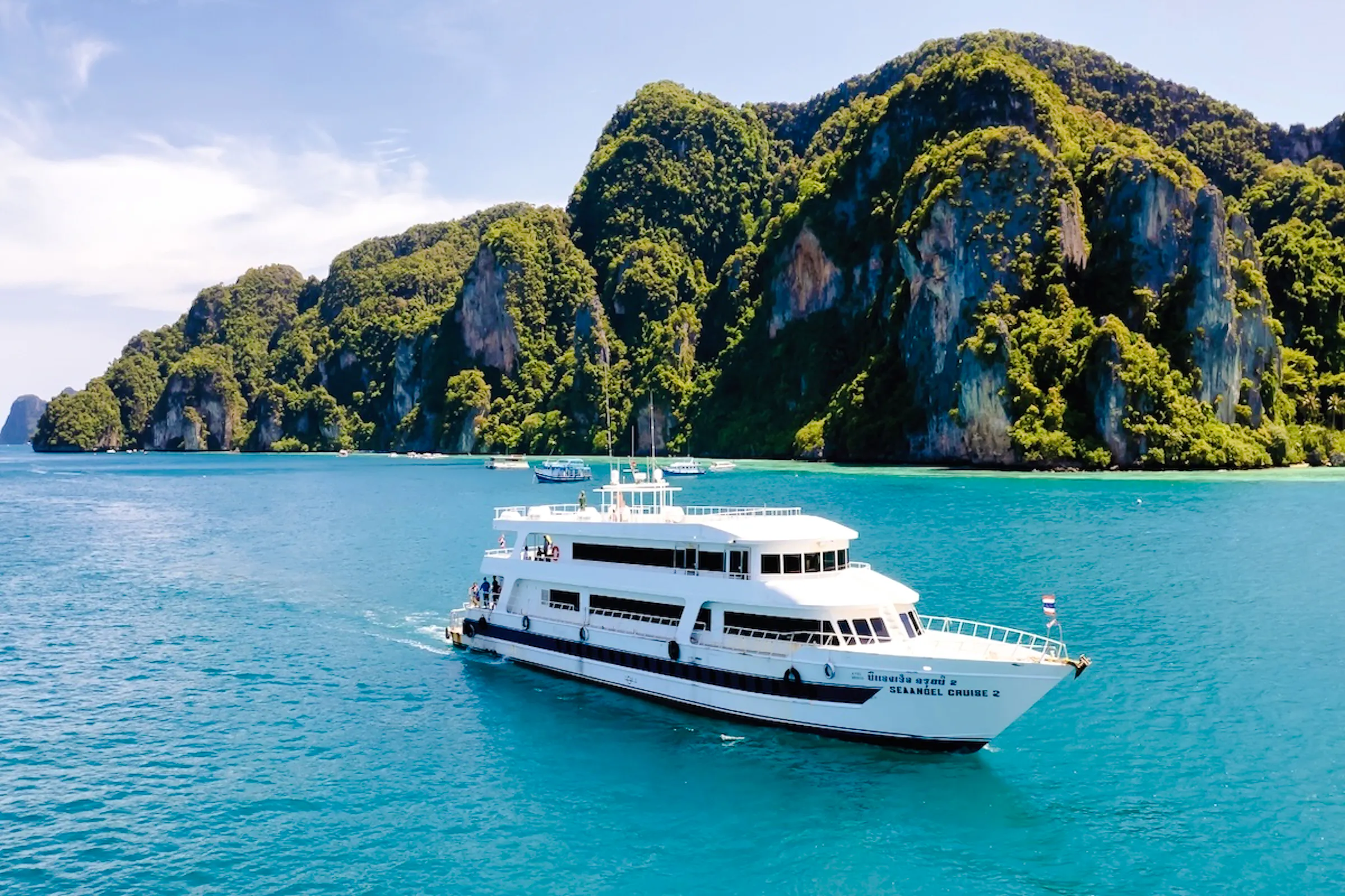 Ferry cruising near limestone cliffs in Phuket on route to Phi Phi Islands.