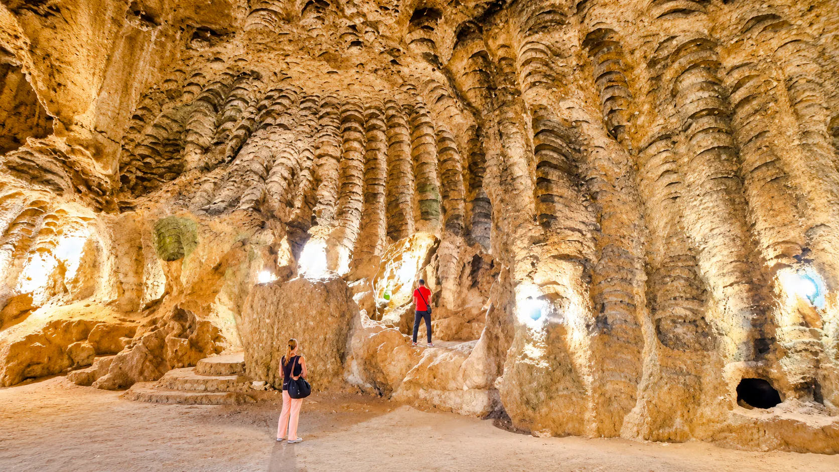 Hercules Caves interior with visitors exploring rock formations, Tangier, Morocco.