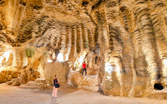 Hercules Caves interior with visitors exploring rock formations, Tangier, Morocco.