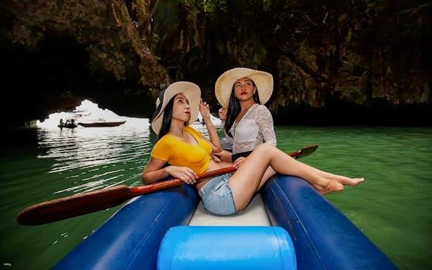 Tourists canoeing through limestone caves in a scenic waterway.