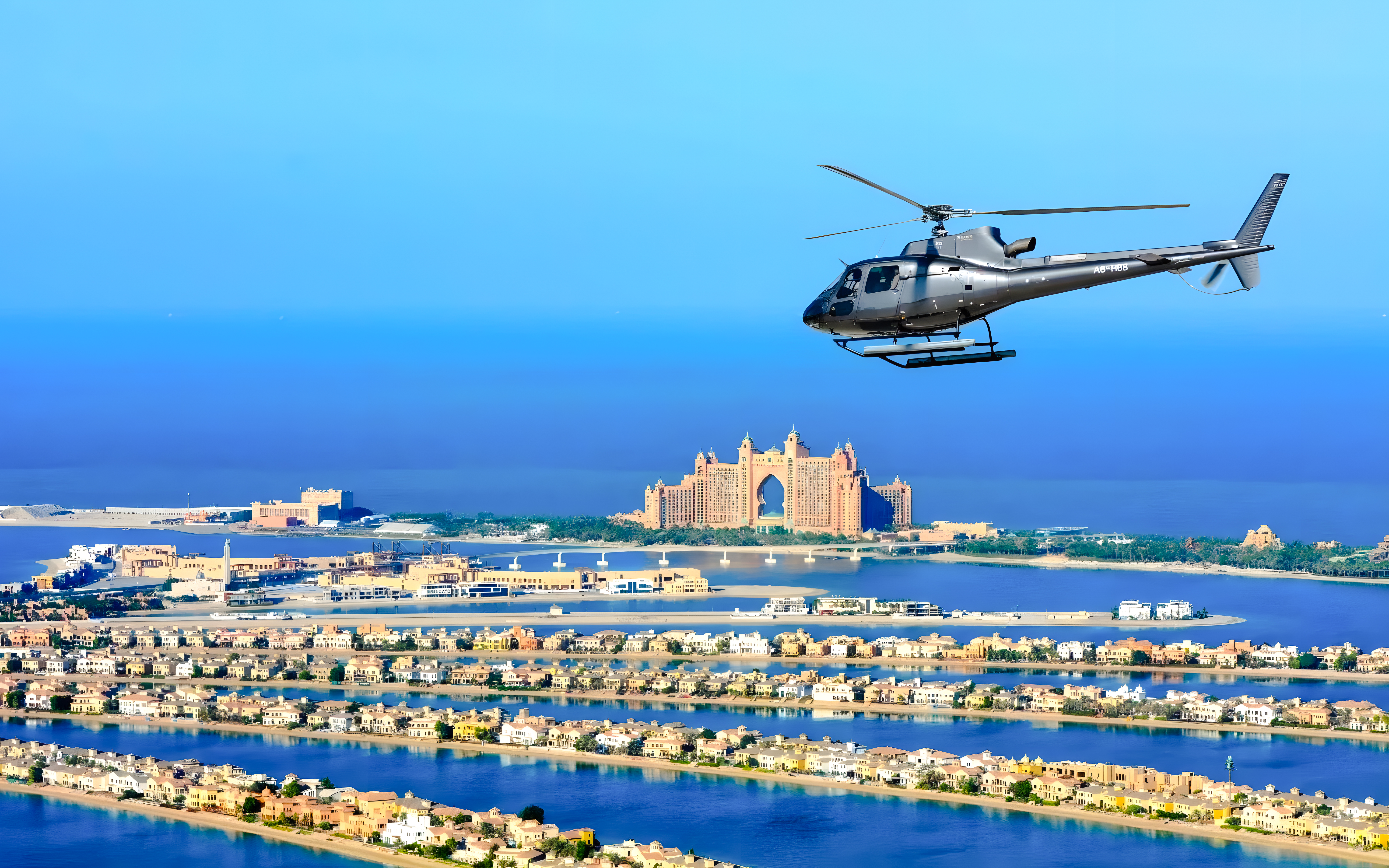Helicopter flying over Palm Jumeirah with Atlantis Hotel in Dubai.