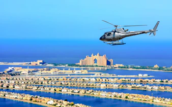 Helicopter flying over Palm Jumeirah with Atlantis Hotel in Dubai.