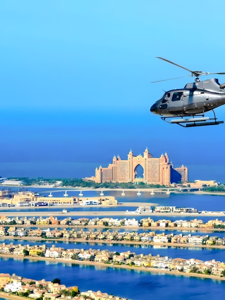 Helicopter flying over Palm Jumeirah with Atlantis Hotel in Dubai.