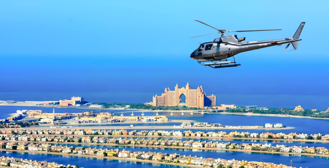 Helicopter flying over Palm Jumeirah with Atlantis Hotel in Dubai.