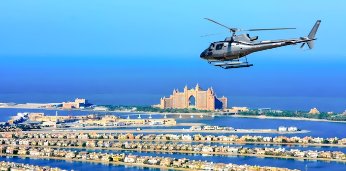 Helicopter flying over Palm Jumeirah with Atlantis Hotel in Dubai.