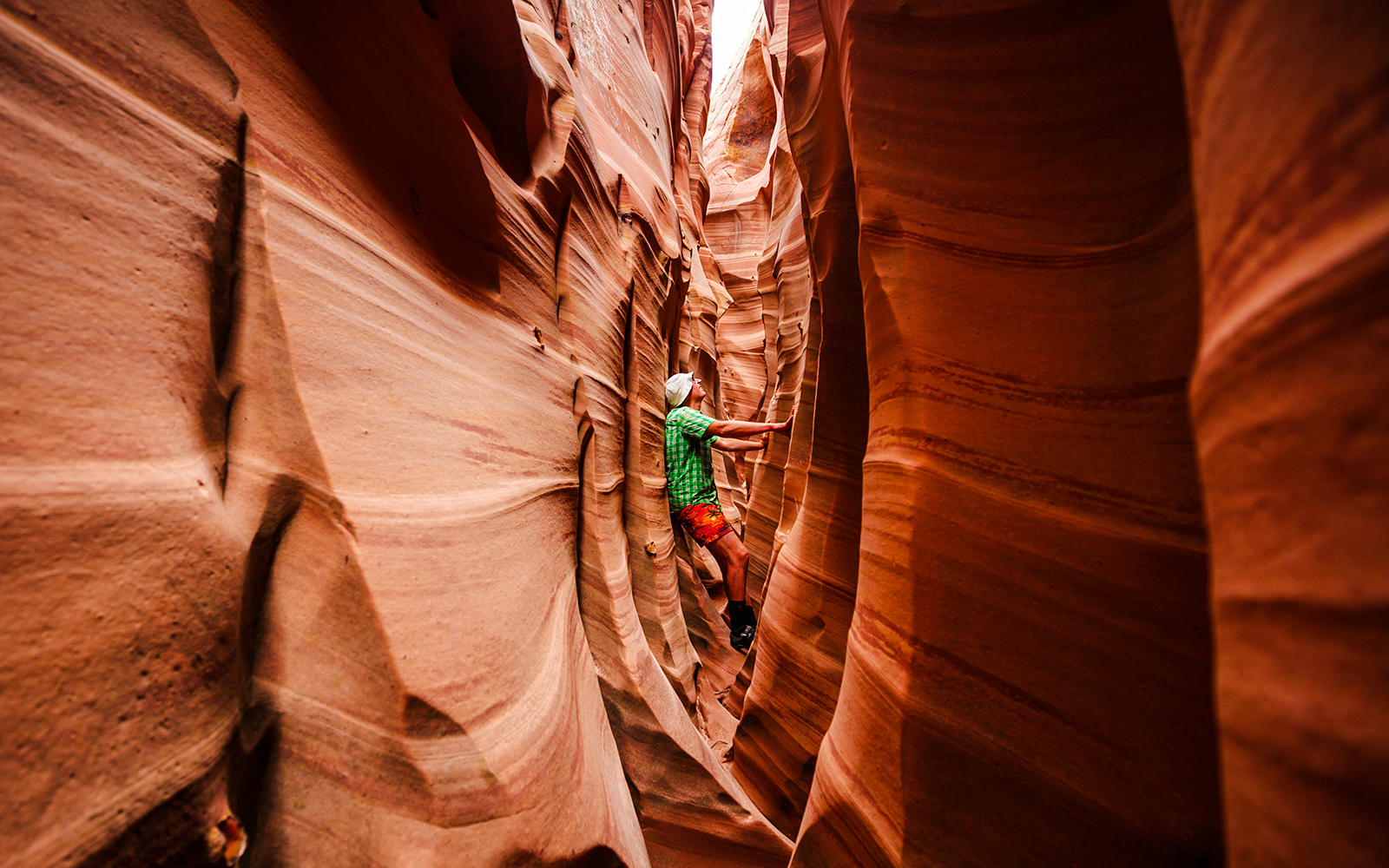Person exploring narrow passage in Antelope Canyon, Arizona.